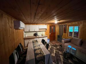 a kitchen and a living room with a table and chairs at Cabana trei paltini in Poiana Vadului