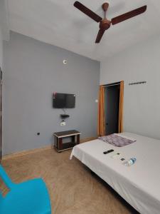 a bedroom with a bed and a ceiling fan at Shree Datt Yatri Niwas Akkalkot in Solapur