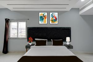 a bedroom with a large bed and two paintings on the wall at Hotel O Erragadda Metro Station Hyderabad Formerly Palak Residency in Ameerpet