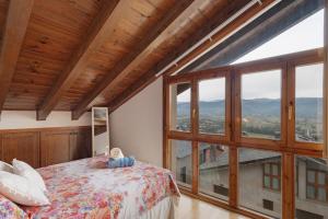 una camera da letto con un letto e una grande finestra di Maravilloso Atico En Puigcerdà a Puigcerdà