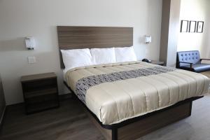 a bedroom with a bed and a chair in it at Hotel Royale - Houston Hobby Airport in Houston +7 photos