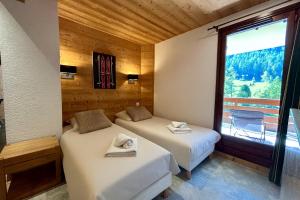 two beds in a room with a window at Chez Charles I Vallorcine Viachamonix in Vallorcine