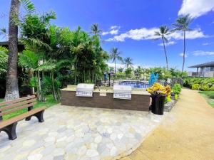 a park with two benches and palm trees at Maui Eldorado Condo F203 in Kaanapali