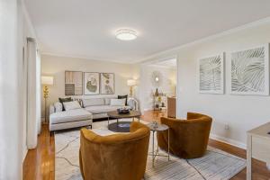 Ultimate Group Escape Heated Pool - 12 Guests في Seven Hills: غرفة معيشة مع أريكة وكرسيين