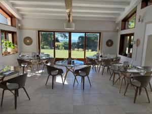 a dining room with tables and chairs and windows at In Secreto in Dunières