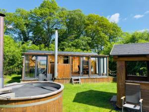 a small house with a hot tub in the yard at wellness vagon in Chlum u Třeboně