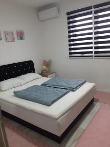 a bedroom with a bed with a blue blanket on it at Apartman Cirkic in Sanski most