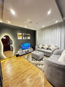 a living room with two couches and a television at لارين سويتس in Jeddah