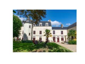 ein großes weißes Haus mit einer Palme im Hof in der Unterkunft Gites Aubelle - La Maison Aubelle in Montreuil-Bellay