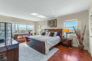 a bedroom with a bed and two windows at Oceanfront Three Bedroom Condo with Panoramic View in Pompano Beach +2 photos