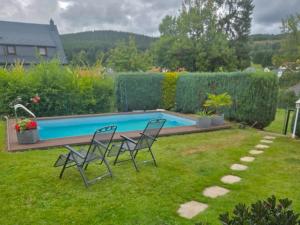 a yard with two chairs and a swimming pool at Alice in Altenfeld