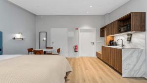 a bedroom with a bed and a kitchen with a table at Candlewood Suites Reykjavik by IHG in Reykjavík