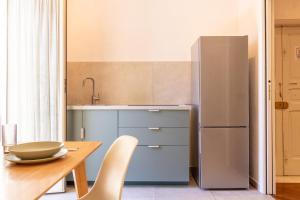 a kitchen with a wooden table and a refrigerator at Apartment Next to St Peter in Rome +23 photos