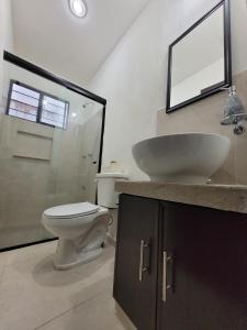 ein Badezimmer mit Waschbecken, Toilette und Spiegel in der Unterkunft Casa Izamal Mérida in Mérida + 12 Fotos