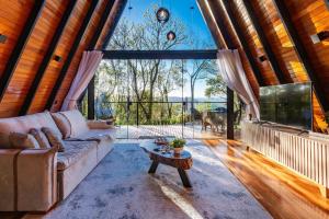 ein Wohnzimmer mit Couch und großem Fenster in der Unterkunft Cabana Lios in Gramado