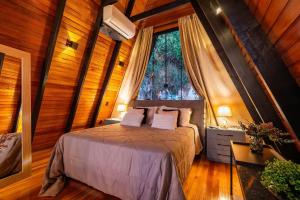 ein Schlafzimmer mit einem Bett in einem Zimmer mit einem Fenster in der Unterkunft Cabana Lios in Gramado