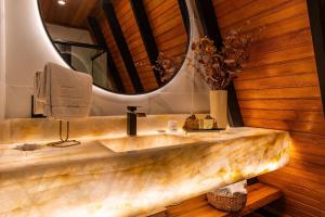 ein Badezimmer mit einem Marmorwaschbecken und einem Spiegel in der Unterkunft Cabana Lios in Gramado + 43 Fotos