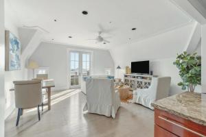 a living room with white walls and a table and chairs at Elegant Three Bedroom Condo Near Rosemary Beach in Rosemary Beach
