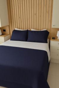 a bed with blue pillows and a wooden headboard at Comfy Loft near El Tesoro MDE OSLO in El Poblado