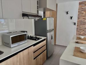 a kitchen with a refrigerator and a microwave at Comfy Loft near El Tesoro MDE OSLO in El Poblado