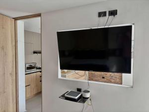 a large flat screen tv hanging on a wall at Comfy Loft near El Tesoro MDE OSLO in El Poblado