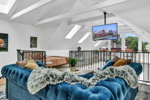 a living room with a blue couch and a tv at Skyline Loft in Buffalo