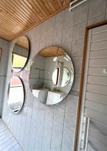 two circular mirrors on the wall of a bathroom at Mysighem Hembackavägen 13 in Vaasa +16 photos