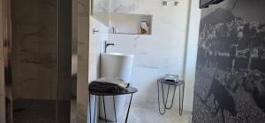 a bathroom with a toilet and two stools at Le Petit Trianon et le Charme des Suites in Nice