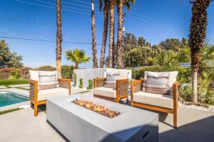 a patio with two chairs and a table with a fireplace at Architectural Villa for Groups 16 Pax in Palm Springs
