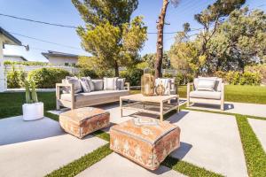 a patio with several chairs and ottomans at Architectural Villa for Groups 16 Pax in Palm Springs