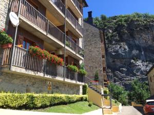 ein Gebäude mit Blumen auf den Balkonen und ein Berg in der Unterkunft Escuacho in Escarrilla