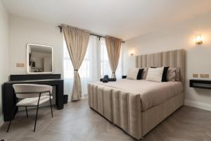 a bedroom with a bed and a desk and a mirror at Entire Aparthotel Bold St 8 Apartments in Liverpool