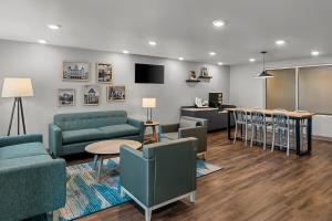 a living room with couches and tables and a bar at WoodSpring Suites Newington - Hartford South in Newington