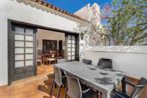 a dining room with a table and chairs on a patio at 3-bedroom Villa in Golf del Sur in San Miguel de Abona