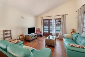 a living room with a blue couch and a tv at 3-bedroom Villa in Golf del Sur in San Miguel de Abona