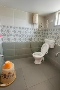 a bathroom with a toilet and a sink at Yashwithaa Homestay Tirupati - New Hill View Apartments with Balcony, AC, WiFi, TV in Tirupati +10 photos