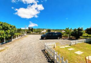 a van parked in a driveway next to a fence at Nanwan chill 在南灣放空 &七桃旅宿 每日限一組 villa泳池獨棟 K歌high天亮 麻將打通宵 星空BBQ 附停車場 歡迎LINE詢問包棟服務 in Nanwan