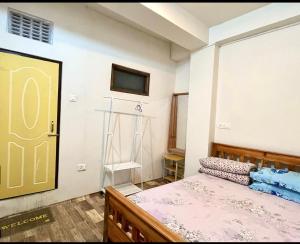 a bedroom with a bed and a tv on the wall at Chasumi Homestay in Darjeeling