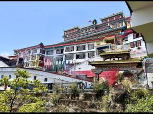 a large white building with a lot of windows at Chasumi Homestay in Darjeeling +3 photos