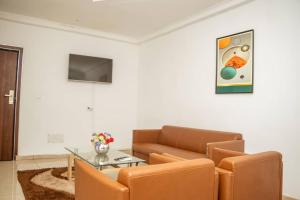 a living room with a couch and a glass table at Hotel Etoile De Kennedy in Bouaké