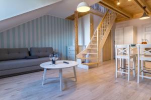 a living room with a table and a staircase at Villa Nautikka in Krynica Morska