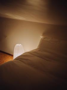 a dark room with a bed and a lamp at Suu -瀬戸内の小さな別邸 in Futami