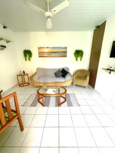 a living room with a couch and a table at Casa Aconchegante Guarujá in Guarujá