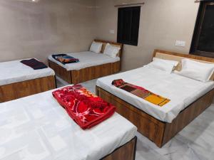 a group of three beds in a room at DYO Shiv Krupa Bhavan in Dwarka