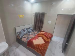 a small bedroom with a bed and a sink at DYO Shiv Krupa Bhavan in Dwarka