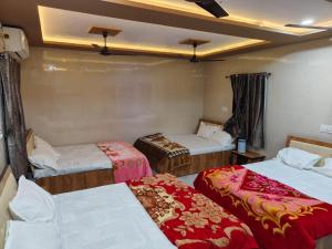 a room with three beds in a room at DYO Shiv Krupa Bhavan in Dwarka