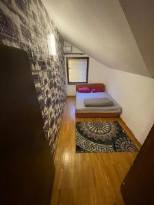 a small room with a bed and a rug at House in Center in Skopje