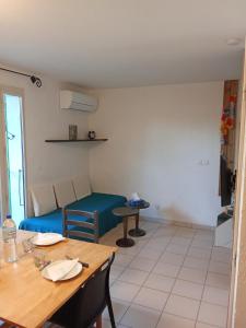 Una sala de estar con una mesa y un sofá azul. en Cosy île des pêcheurs 4 p, en Le Barcarès 12 fotos más