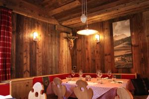 uma sala de jantar com uma mesa com copos de vinho em Garnì Ladin em Vigo di Fassa