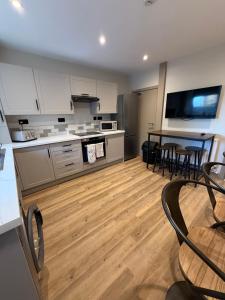 a kitchen with white cabinets and a wooden floor at 128-130 Crookes in Sheffield